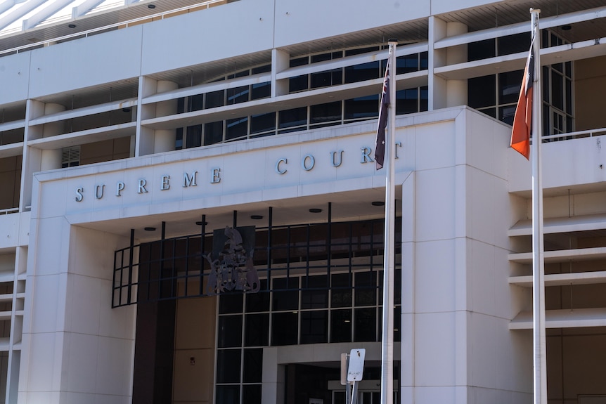 A shot of a building, supreme court, with flags outside.