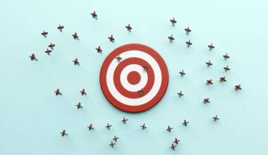 A dartboard with only a few darts hitting it, with many misses beside it.