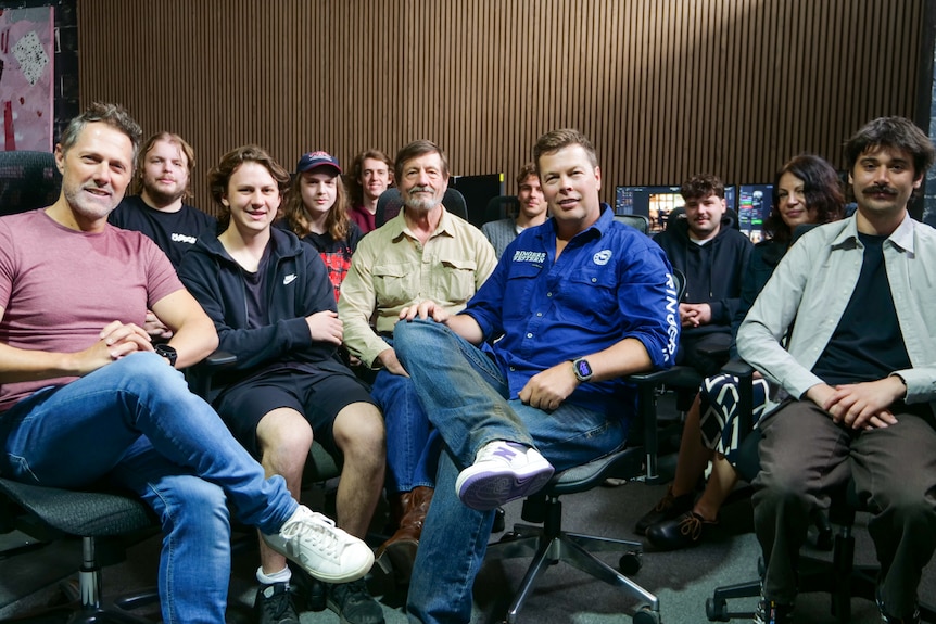 A room of people in chairs in front of their workstations. 
