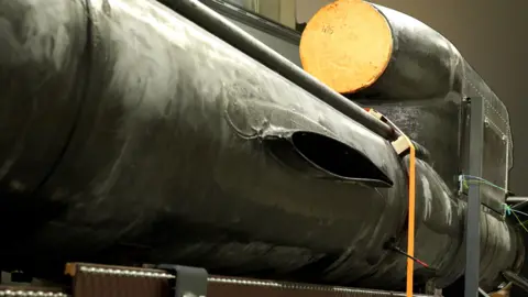 Moose Campbell/BBC An incomplete Flamingo missile sits in a factory in Kyiv - a long, black body with an engine on top