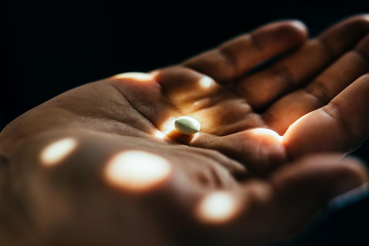 hand with medicin pill, close up.