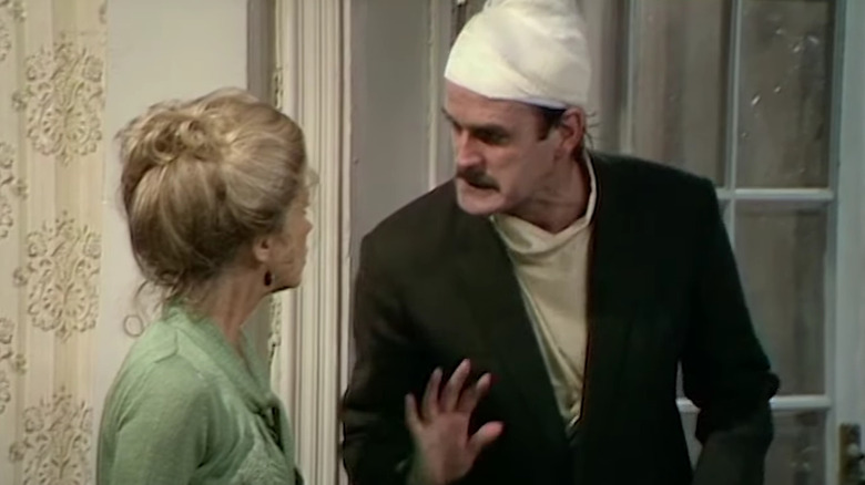 John Cleese as Basil Fawlty tries not to mention World War II to Germans, as Connie Booth's Polly can only look on helplessly, in Fawlty Towers.