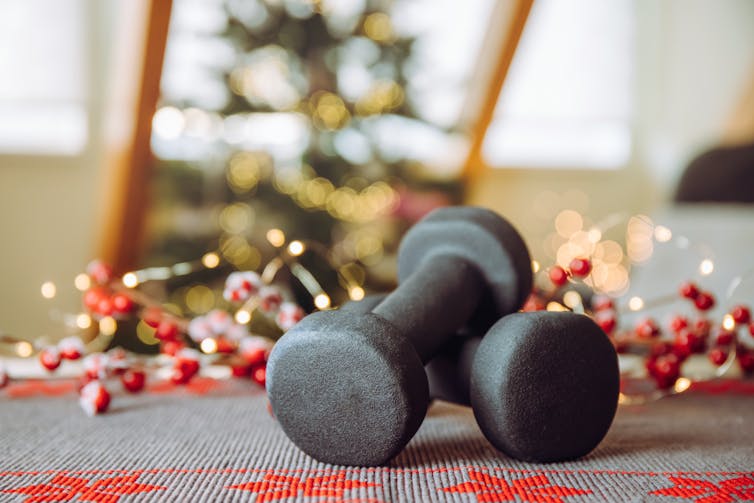 Black dumbbells with blurred Christmas decorations in background
