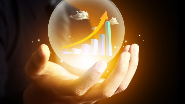 hand holding crystal ball with graph