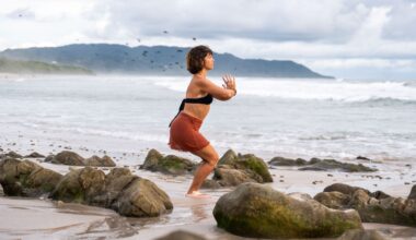 woman on beach doing standing yoga