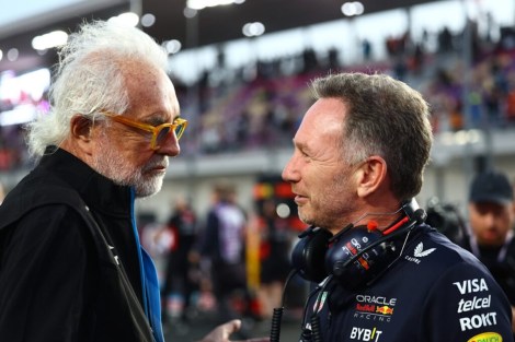 Two men, Horner and Briatore, conversing at a racetrack.