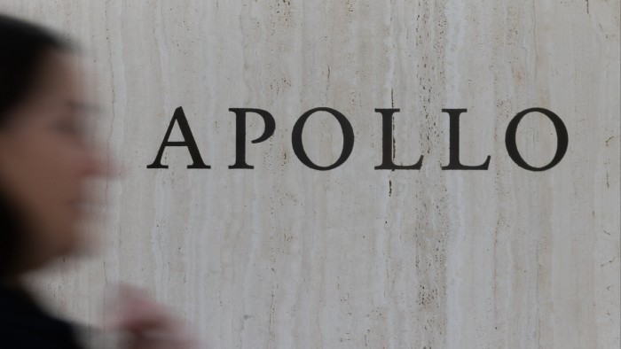 Apollo Global Management signage on a marble wall, with a blurred person passing in the foreground.