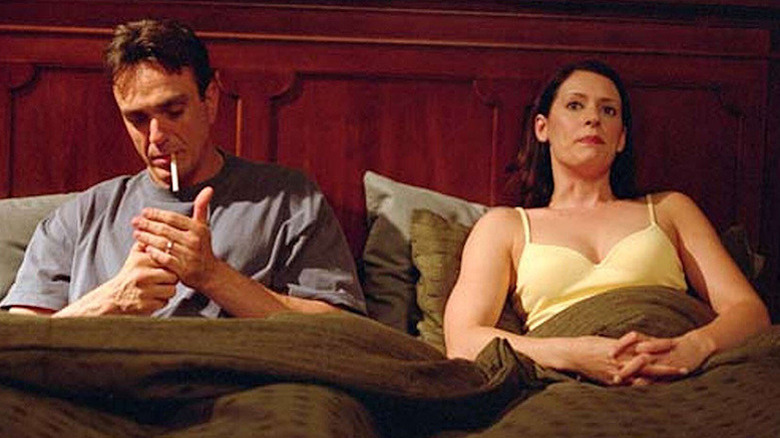 Hank Azaria as Huff sitting in bed smoking cigarette next to Paget Brewster as Beth in Huff