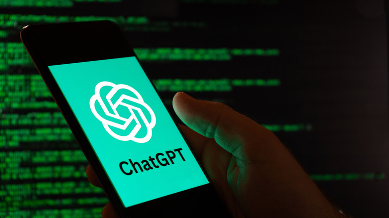 A hand holding a phone with ChatGPT logo over a spooky, black, code-on-terminal background