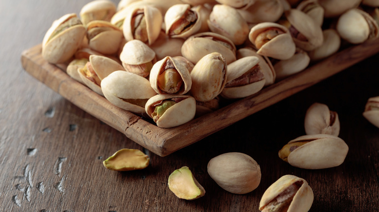 wooden board with pistachio nuts closeup