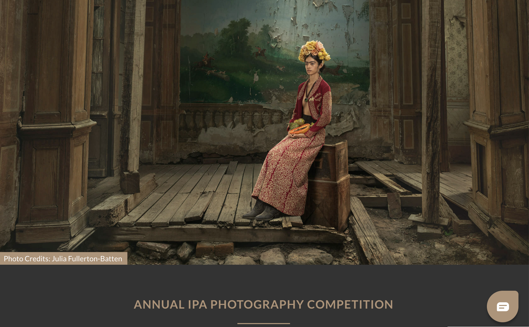 A promotional image for the Annual IPA Photography Competition, featuring a photograph of a woman wearing a flower crown and a patterned dress, sitting in a dilapidated wooden room with a painted wall in the background.