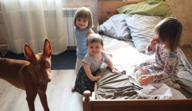 3 kids and a dog posing in front of one bed