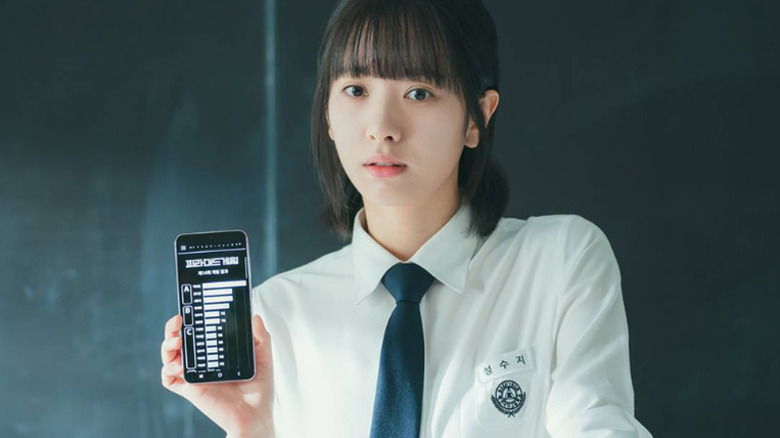 Seong Su-ji (Kim Ji-yeon) shows the student rankings on her phone on Pyramid Game