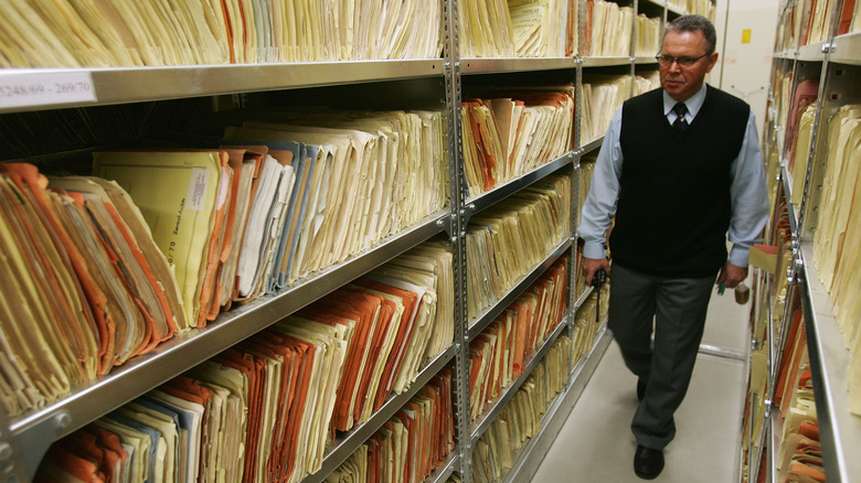 A man walking through a row of archived file folders