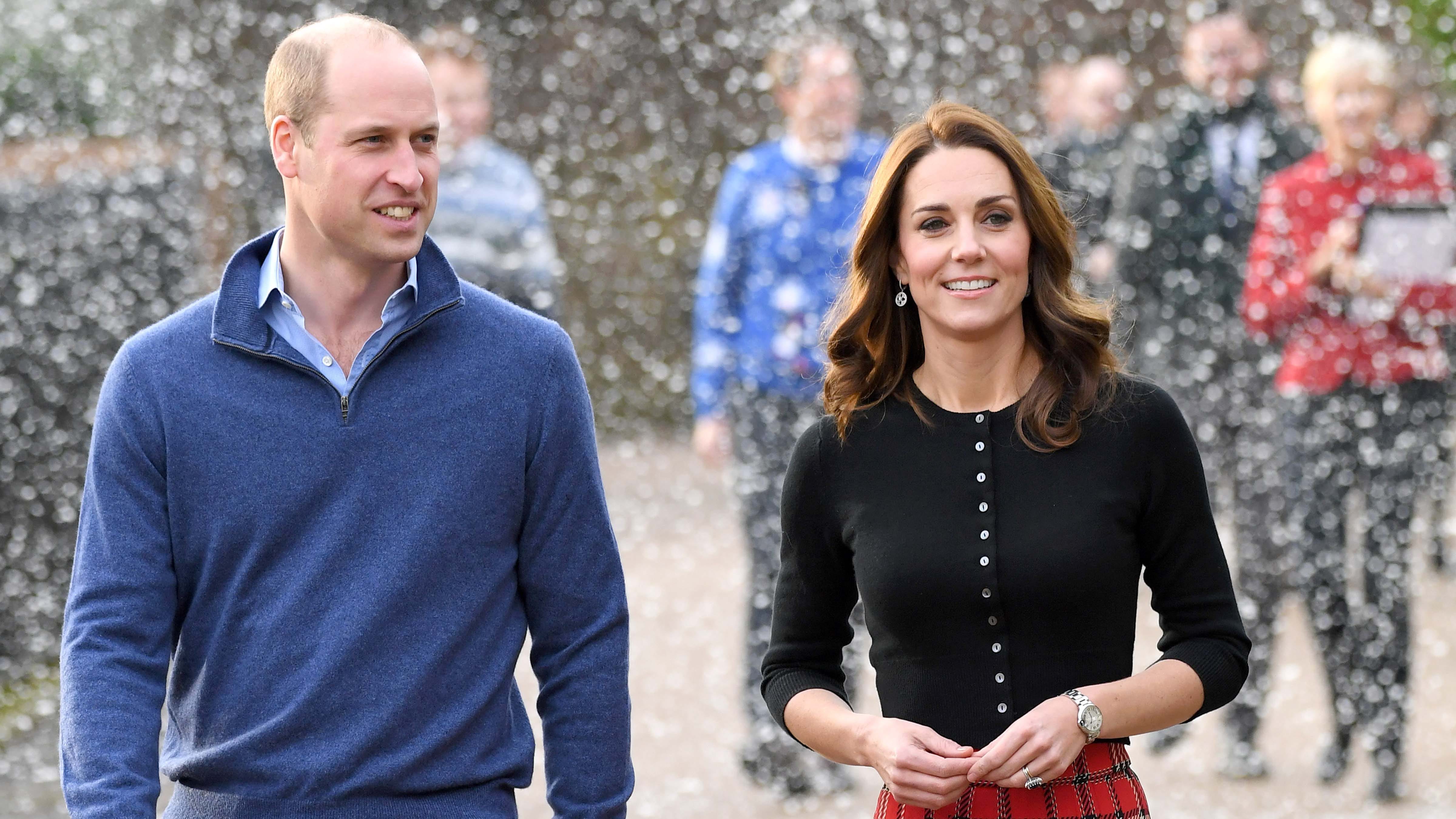 Two individuals standing by a piano adorned with flowers.