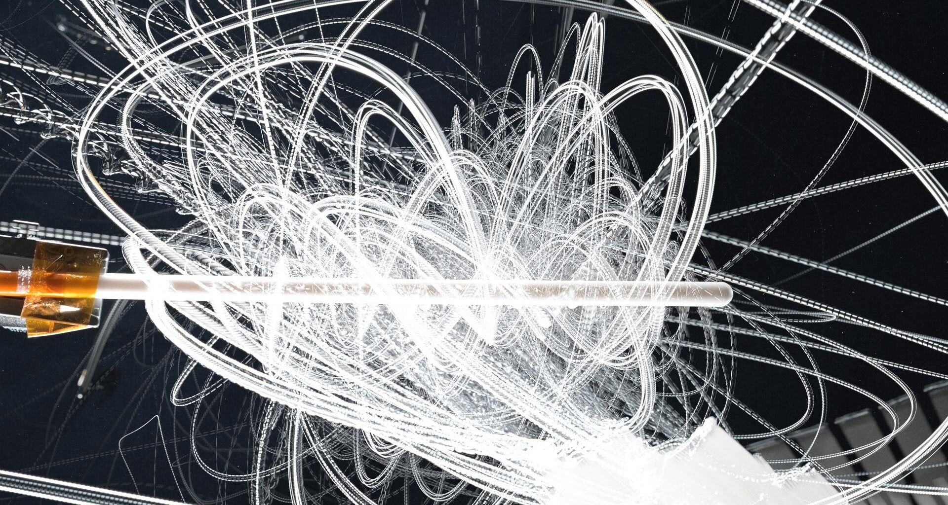 White streaks of motion swirl and swoop all over the image. At the middle of the image is a Teflon knitting needle.