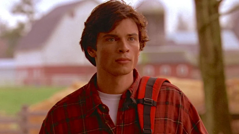 Clark Kent (Tom Welling) stands in front of a farm in Smallville