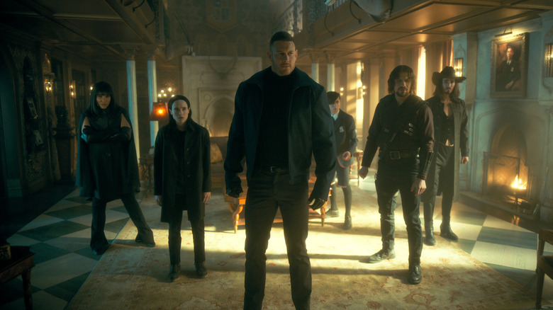 The Hargreeves stand together by a fireplace in The Umbrella Academy