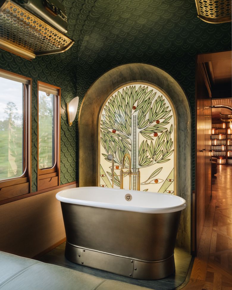 A freestanding bath in front of a stained-glass window designed by a Germany artisan.