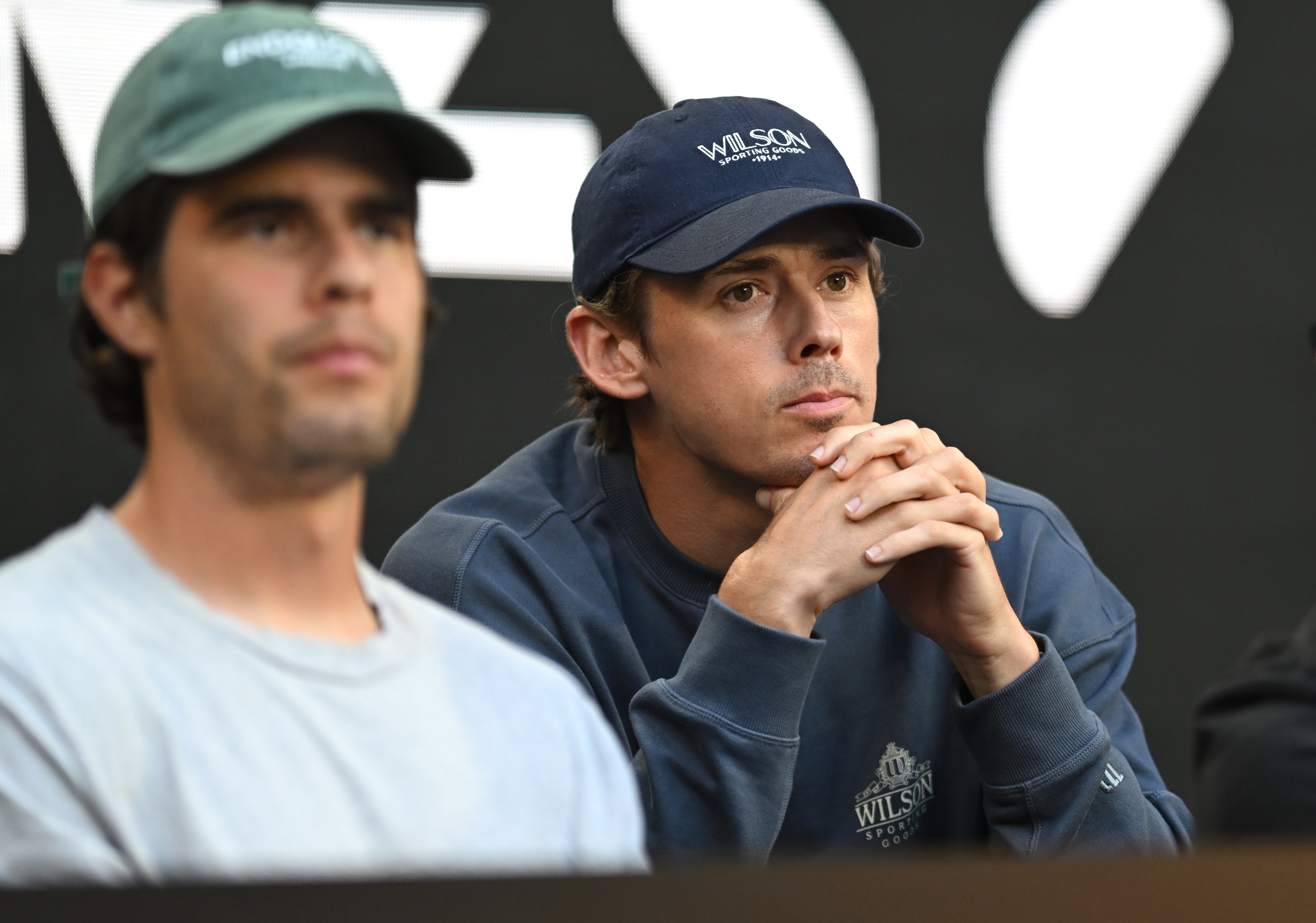 Alex de Minaur watching a women's singles match at the Australian Open.