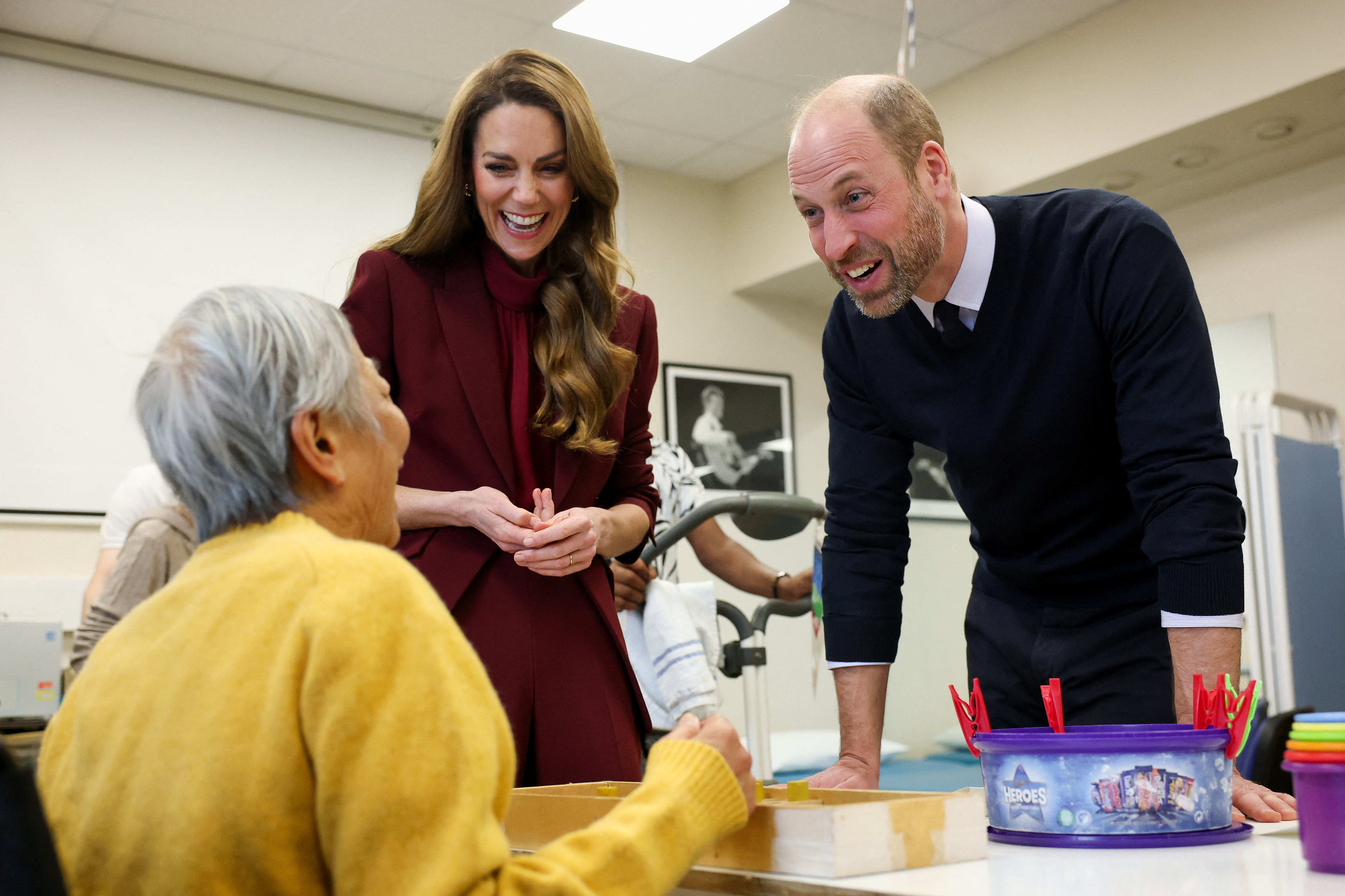 Prince William and Catherine speak to a patient at a hospital therapy gym.