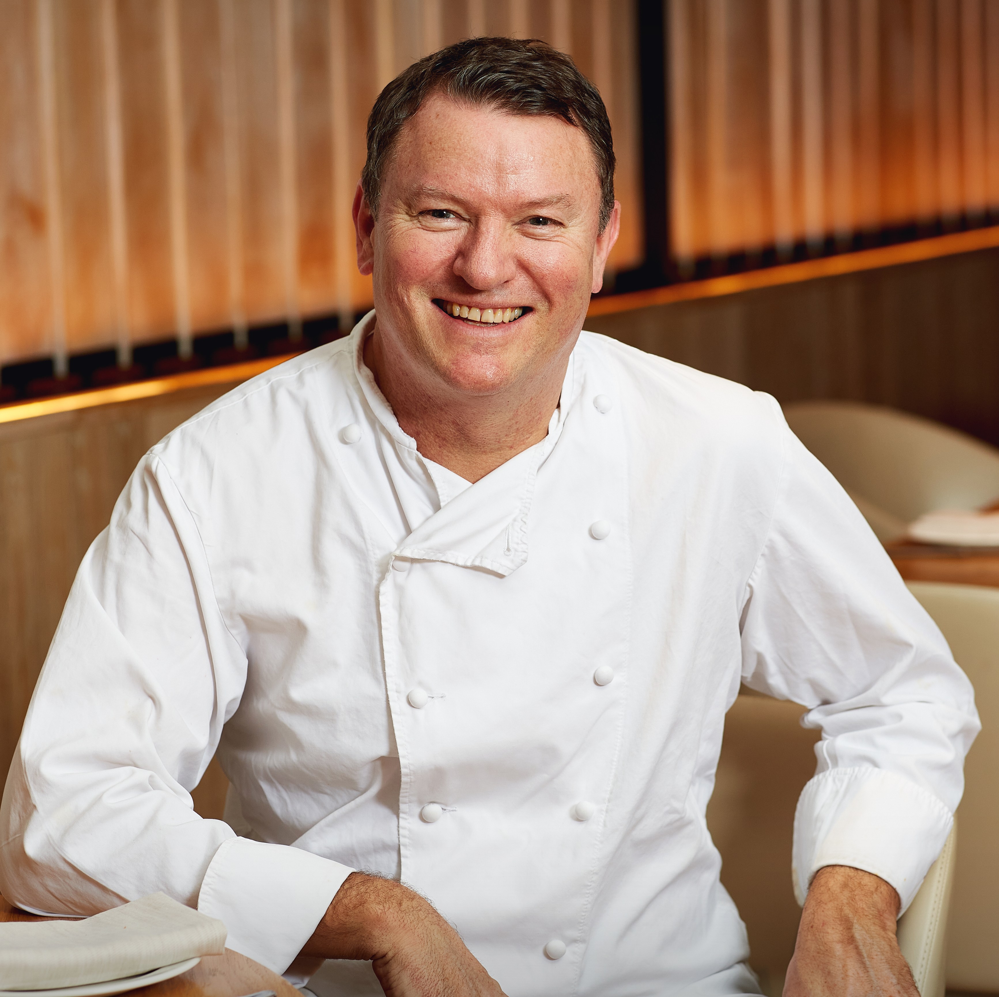 Theo Randall, a chef, smiling in a restaurant.
