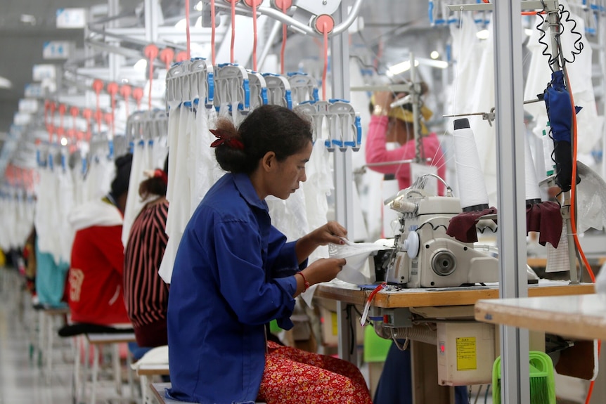Woman using a sewing machine in a factory.
