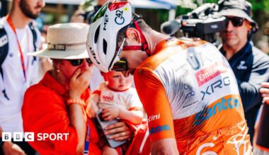 Cyclists ride past a kangaroo sign