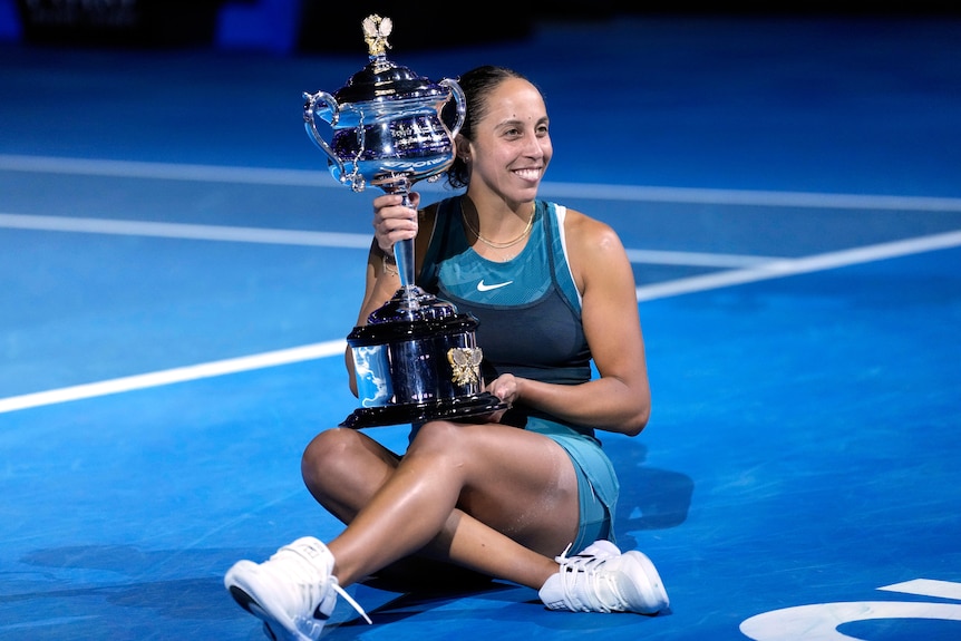 Madison Keys sitting on Rod Laver Arena with her Australian Open trophy