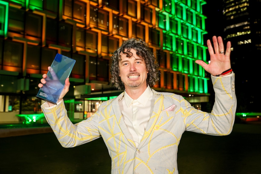 A man holding a trophy.