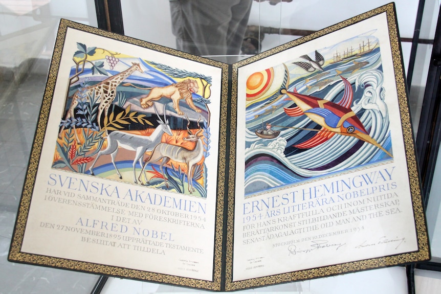 A photo of a Nobel diploma awarded to Hemingway with colourful illustrations of animals.