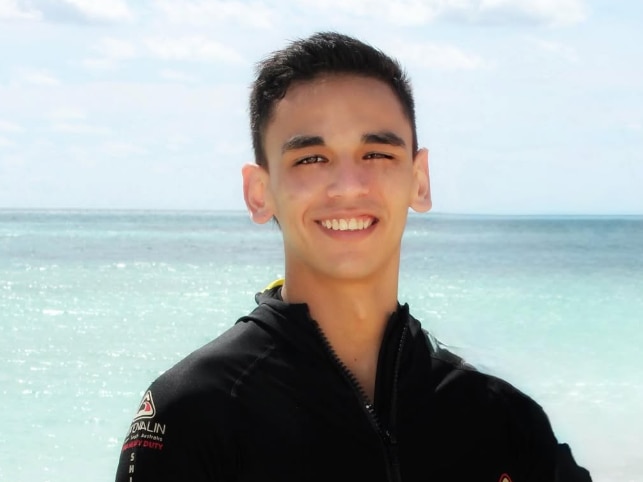 man smiles with water in background
