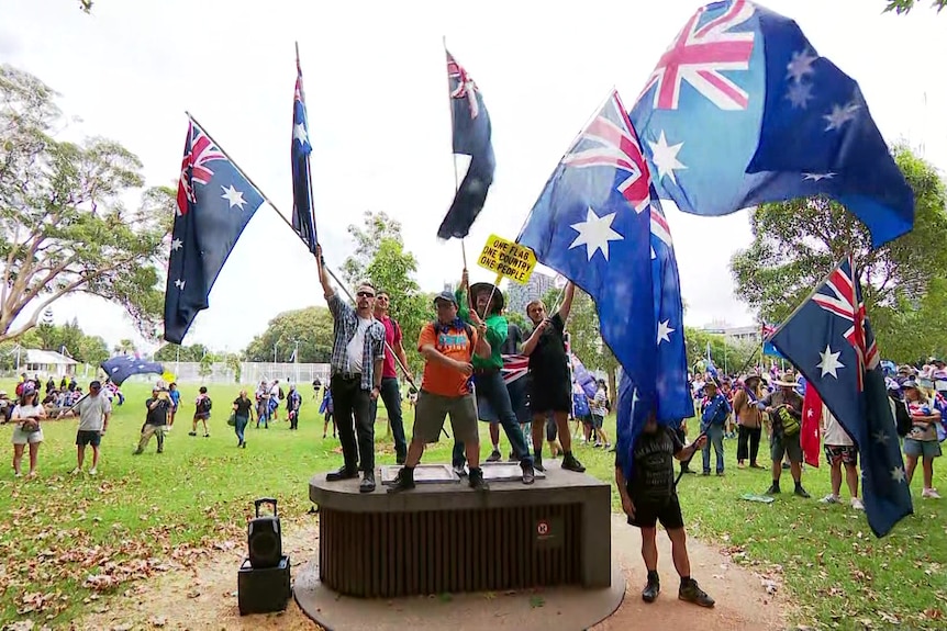 People on a podium waving Australian flags