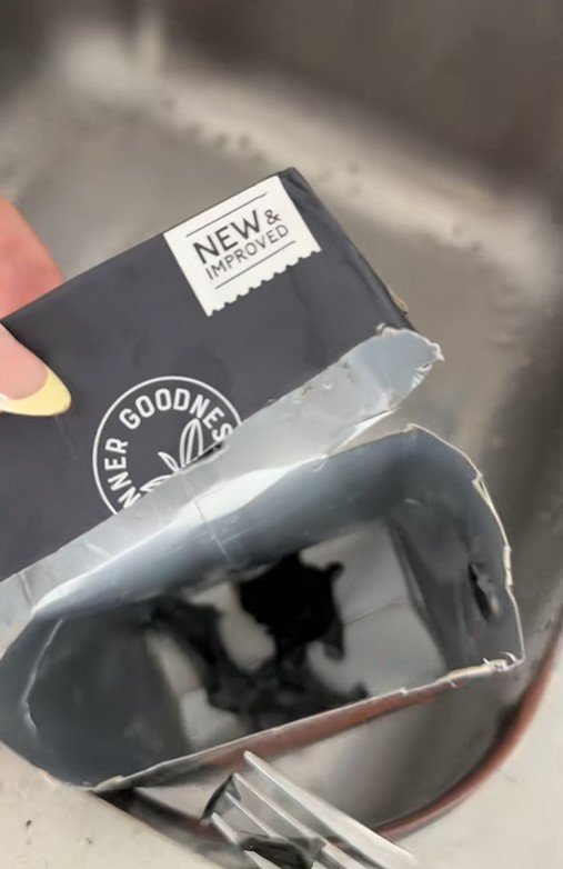 The black object at the bottom of the almond milk container.