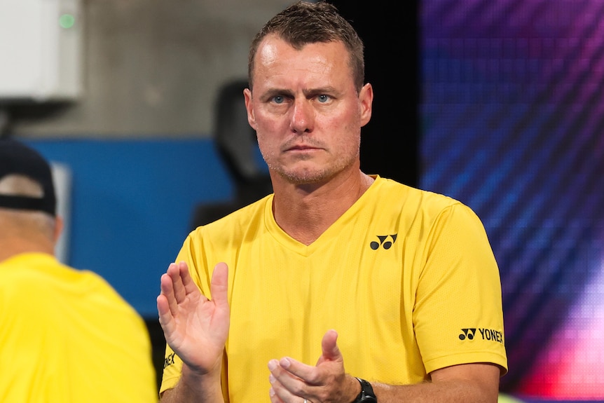 A man in a yellow shirt claps