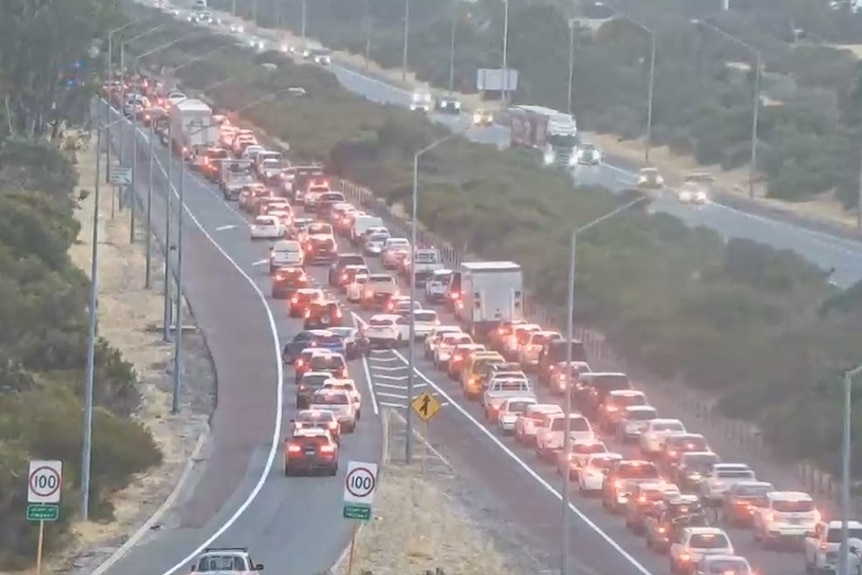 A freeway with one side gridlocked with traffic congestion.