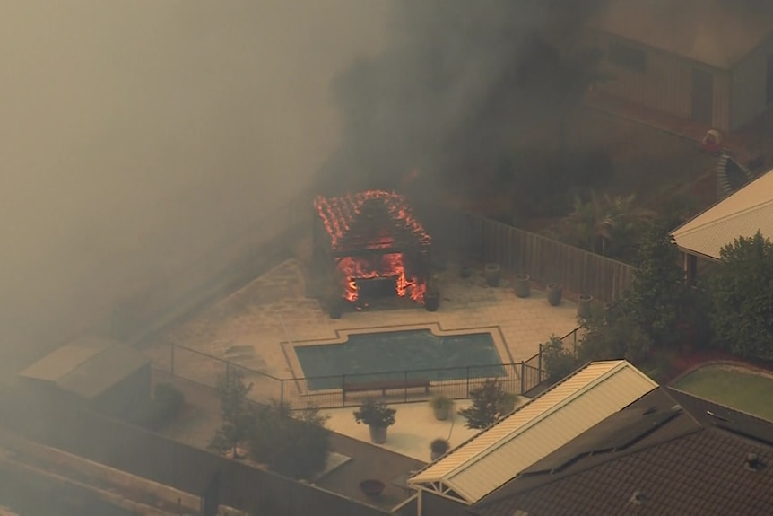 A cabana is engulfed in flames. 