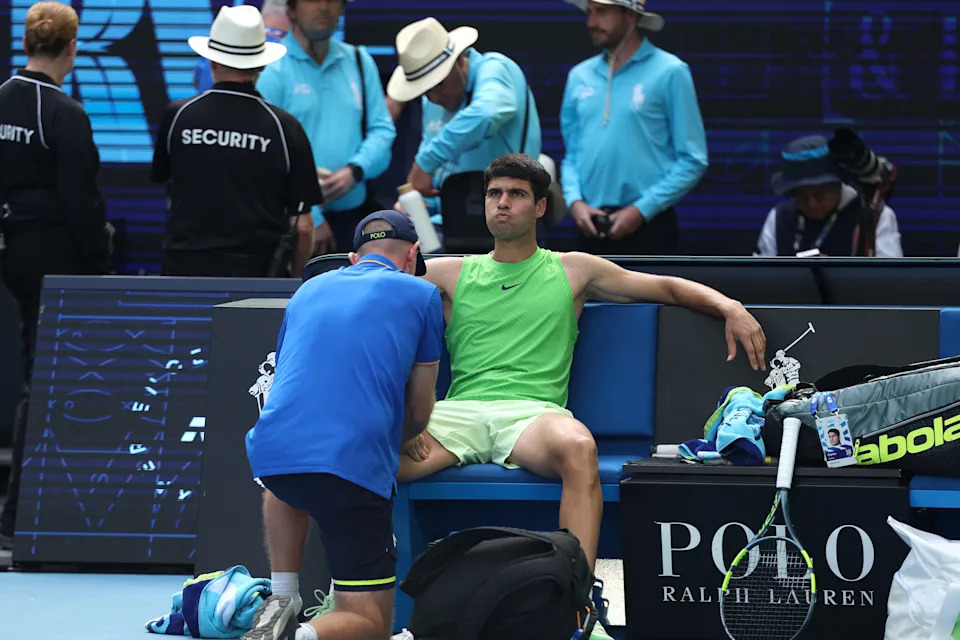 Carlos Alcaraz receives medical attention.