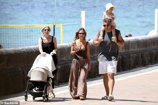 Sam Burgess took his young family for a stroll along Sydney's Coogee Beach on Sunday, only weeks after welcoming his second child