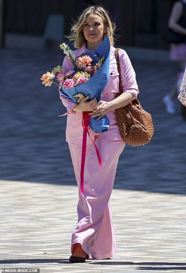 She added a pair of towering black heels and carried a designer handbag in a thatched brown fabric