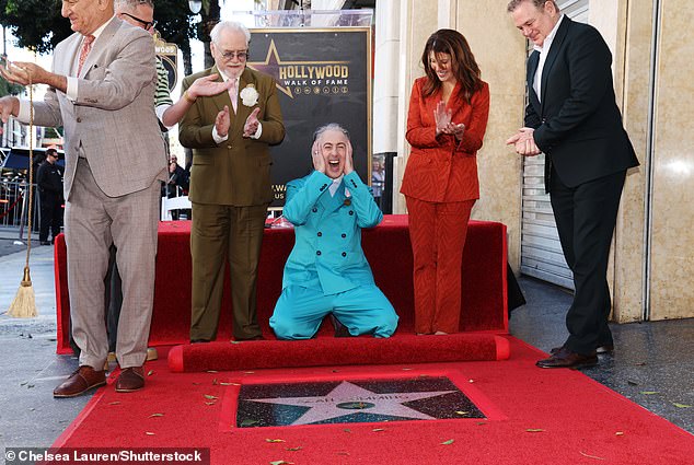 Capping off the star-studded moment, Cumming dropped to his knees in front of the star for a hilarious candid snap with Lewinsky and Cox looking on