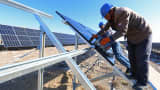 Workers install solar panels at the construction site of a photovoltaic plant on November 10, 2021 in Zhangye, Gansu Province of China.