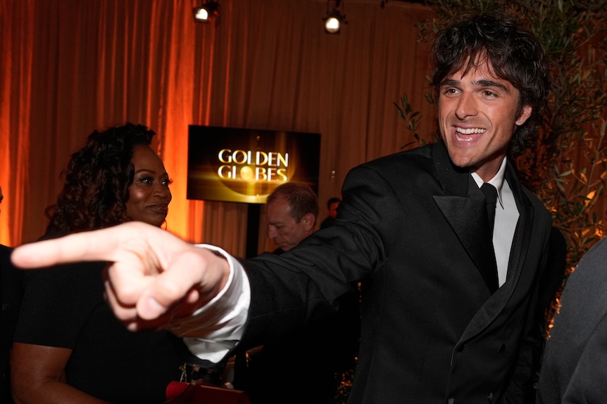 A man points his finger in a tux. 