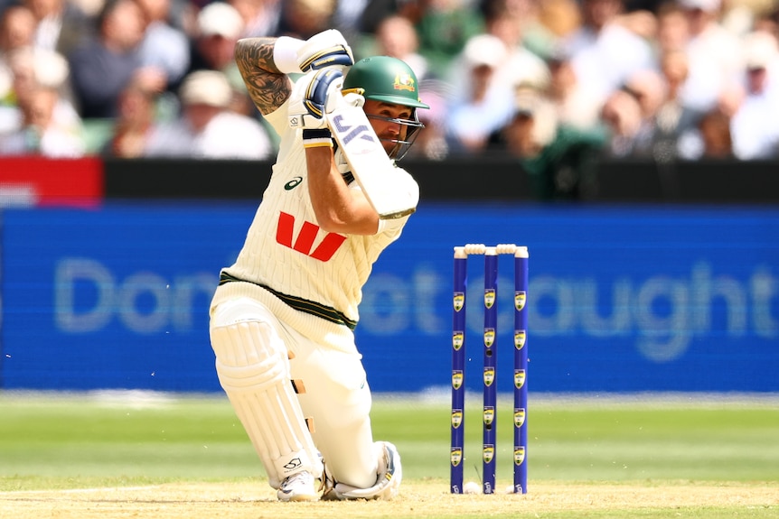 Australia batter Jake Weatherald plays a cover drive while down on one knee during a Test.