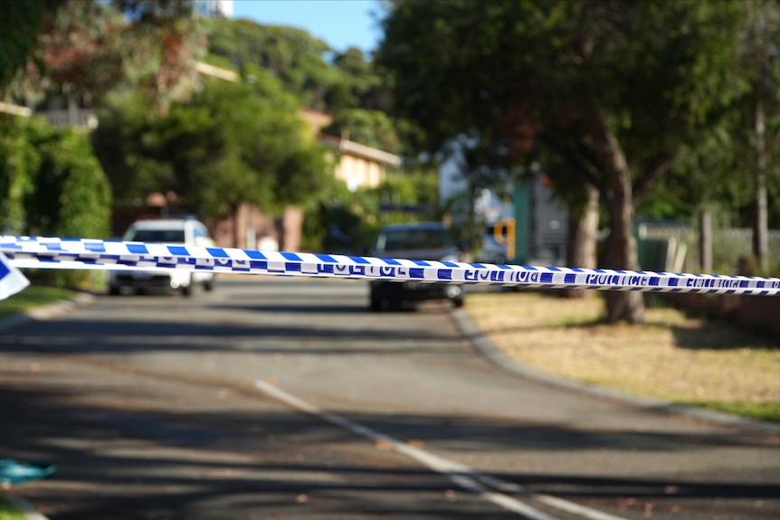 Police tape across a suburban street