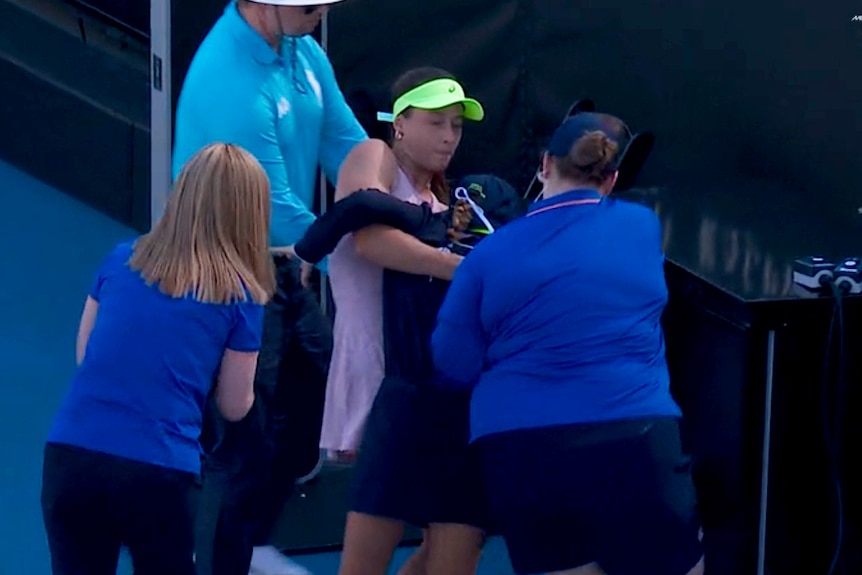 Zeynep Sönmez carries a ball kid into the shade