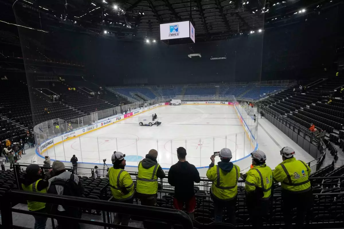 Workers take a break at the Santa Giulia Ice Hockey Arena, where Ice Hockey discipline of the Milan Cortina 2026 Winter Olympics will take place, in Milan, Italy, Friday, Jan. 9, 2026. (AP Photo/Luca Bruno)