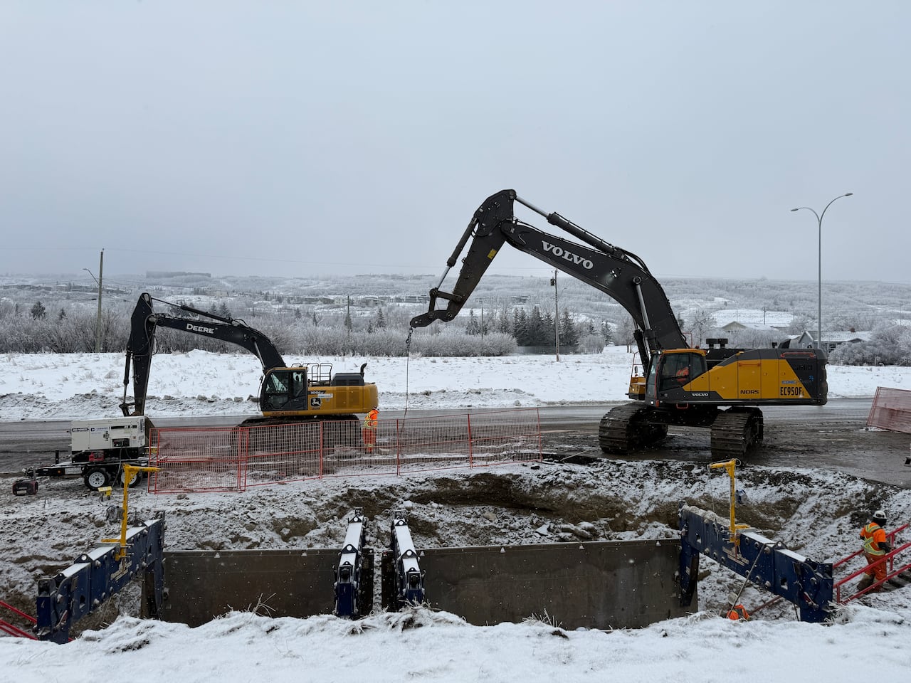 Construction crews work around a large hole in a roadway