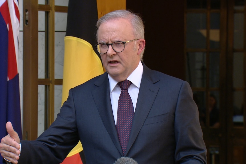 Prime Minister Anthony Albanese stands at a lecturn talking to the media
