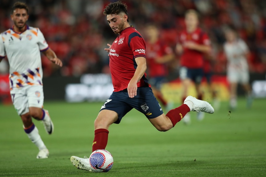 Josh Cavallo kicking the ball with his left foot in an A-League Men match.